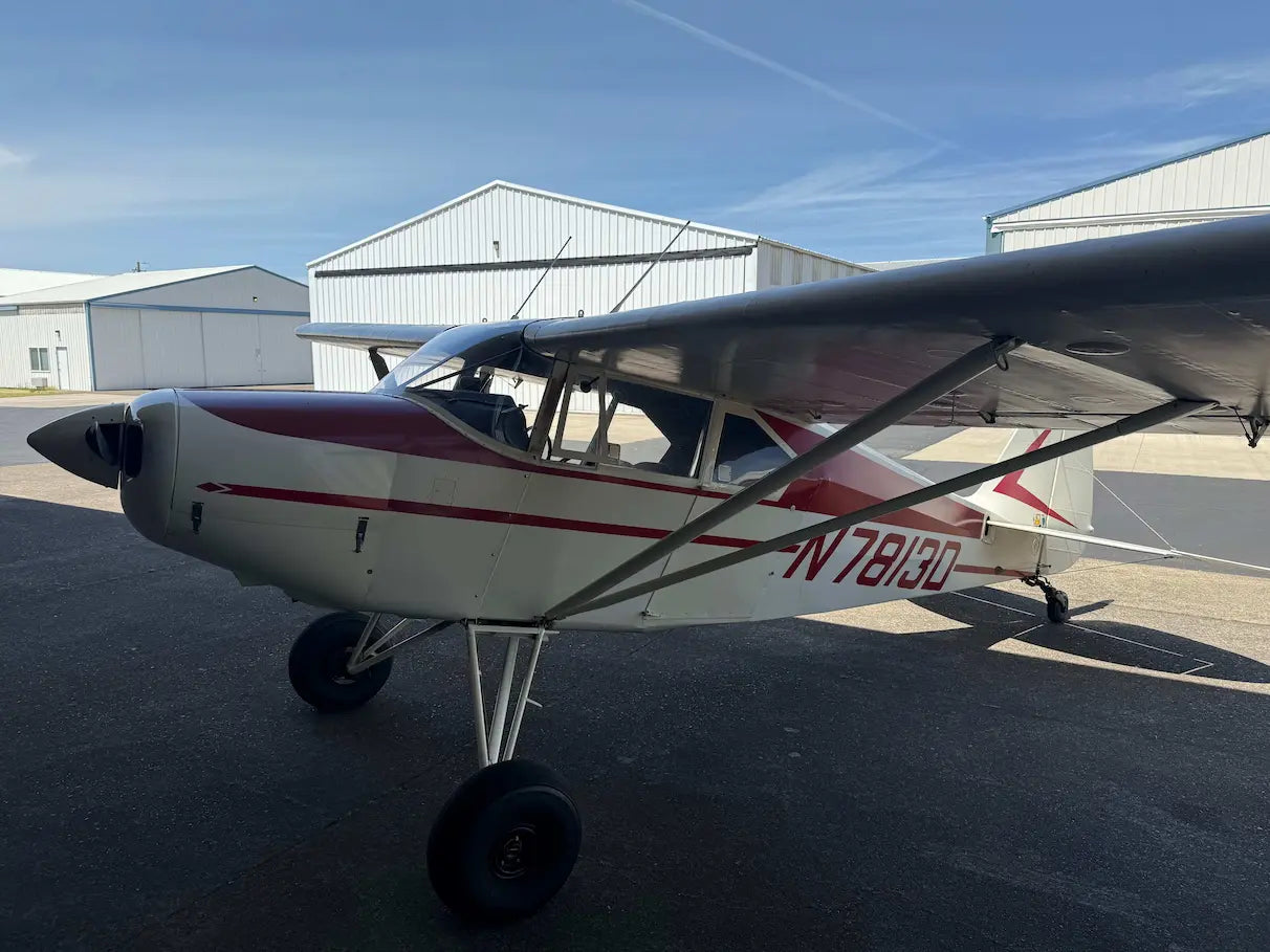 Small airplane on the Aurora tarmac with hangars in the background