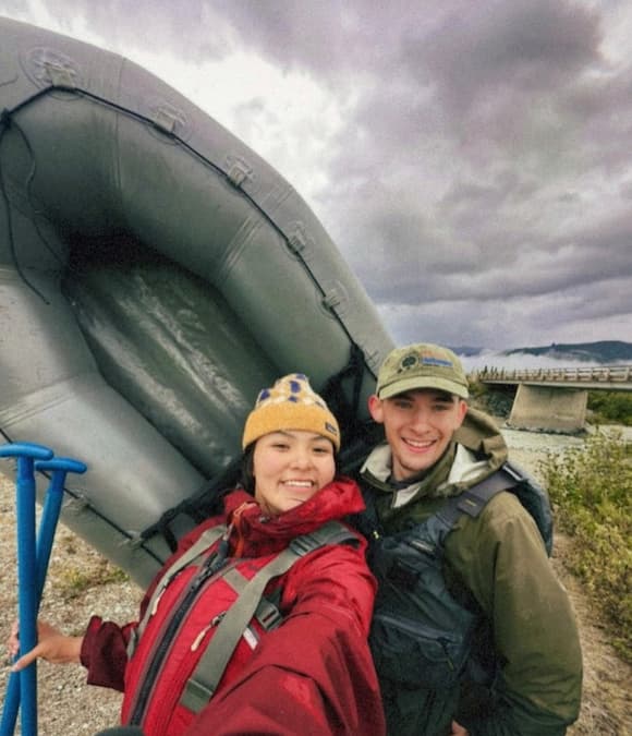 Two people with an inflatable raft on a cloudy day