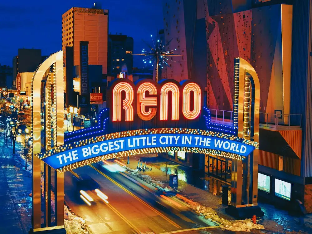 Neon sign for Reno, Nevada with cityscape background