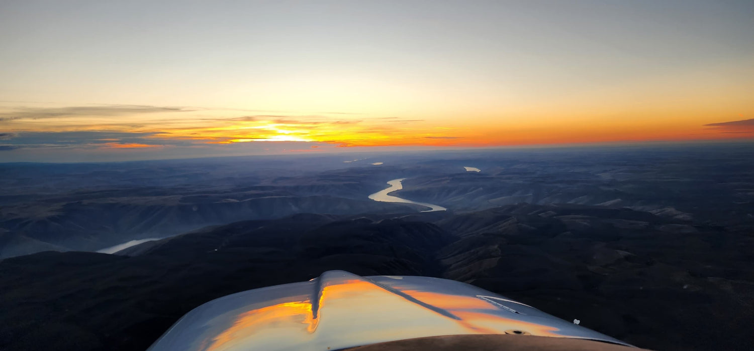 Sunset over a landscape seen from the cockpit of an airplane