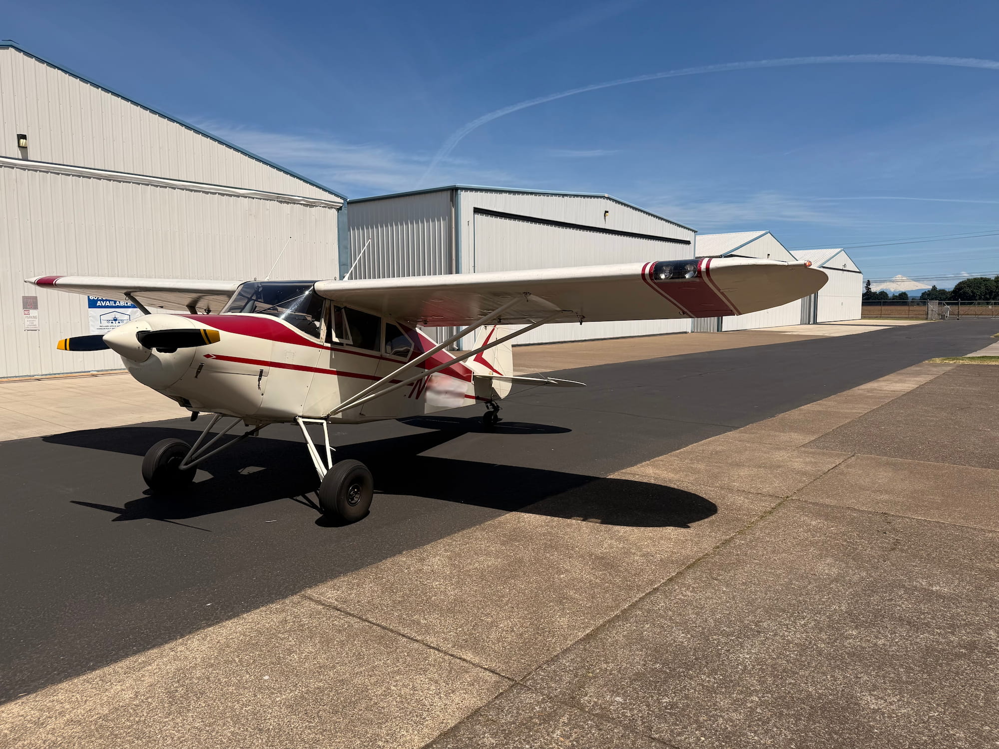 Tailwheel airplane on a tarmac with hangars in the background ready for back country flying. 