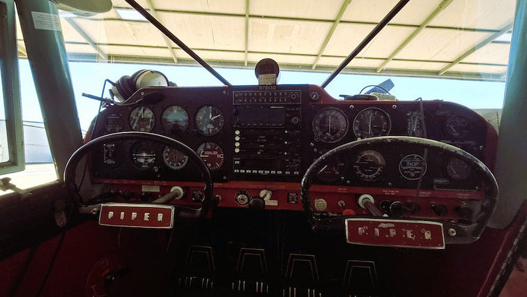 Airplane cockpit interior with instrument panels, round dials, two hand wheels