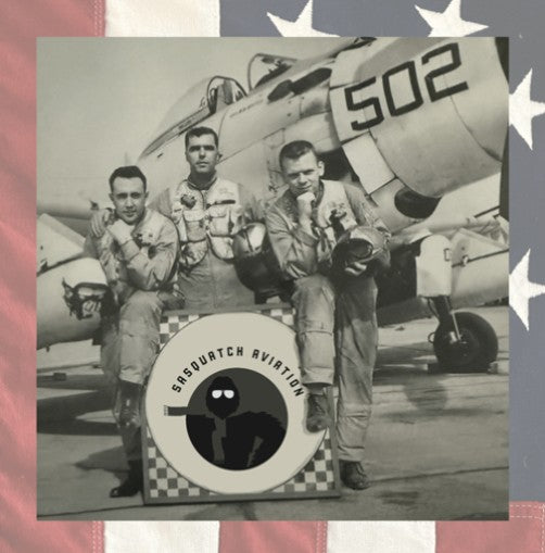Vintage black and white photo of three men in military uniforms sitting in front of an airplane with '502' on the wing. 'Sasquatch Aviation' logo is overlaid.